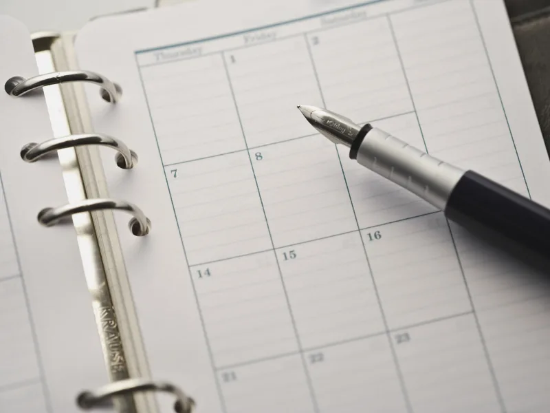 Agenda aberta com caneta sobre a página do calendário